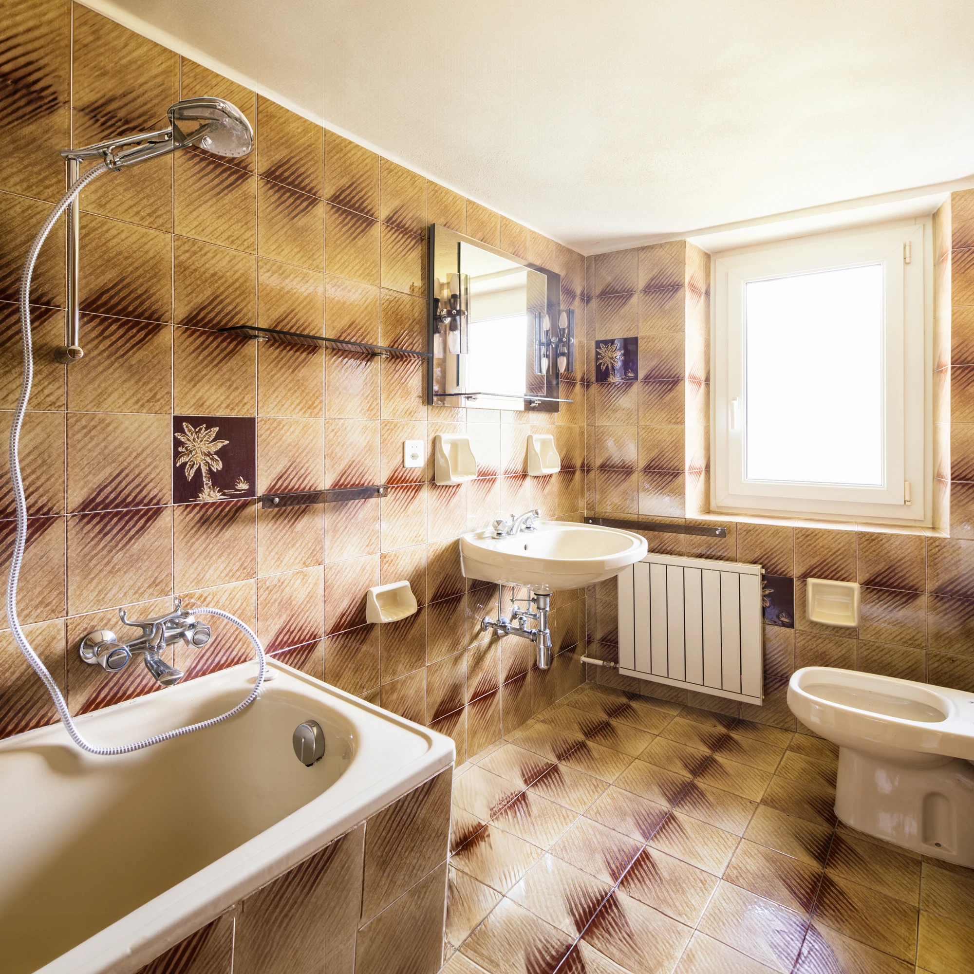 Ein Badezimmer im 70er Jahre Stil mit braunweißen Kacheln, Badewanne, Toilette und Waschbecken